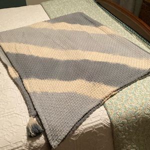 Lap throw with tasseled corners.